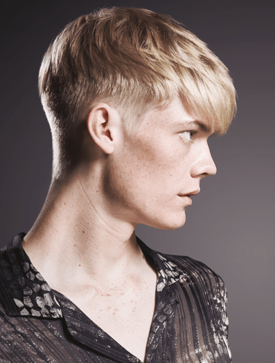 Side profile of a young man with a textured crop haircut dressed in a black shirt
