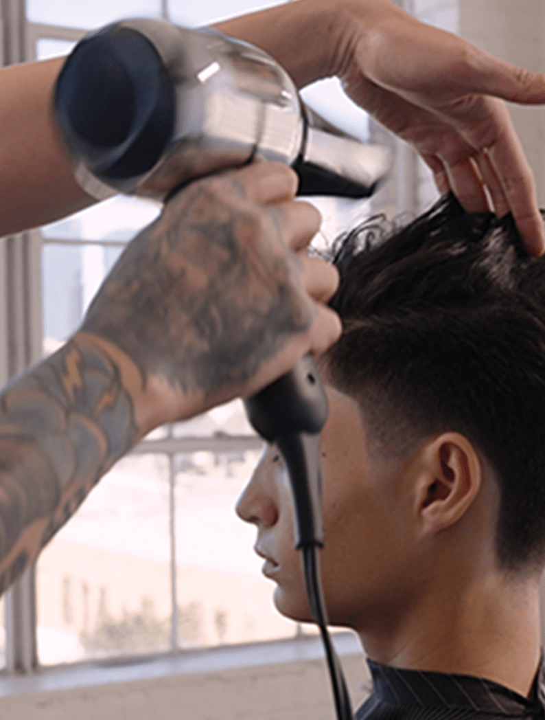 Barber using Wahl Barber Dryer to style model's hair